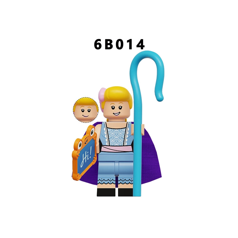 A toy minifigure with blonde hair, a purple cape, and a blue staff, shown on a plain white background with the text '6B014' above it. The figure holds an orange sign reading 'Hi!' and stands next to a small round accessory piece.