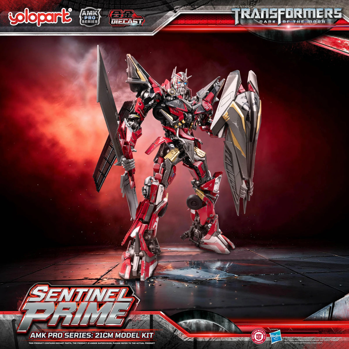 Alt Text 1 (Full Body Front View): A high-detail studio promotional shot of the 21cm YOLOPARK AMK PRO Series Sentinel Prime model kit from Transformers: Dark of the Moon. The figure stands in an imposing front pose, showcasing screen-accurate multi-layered armor plates in premium metallic red and dark silver finishes. Weathered battle-damage paint detailing and glowing blue LED eyes are visible across its screen-accurate mechanical design.